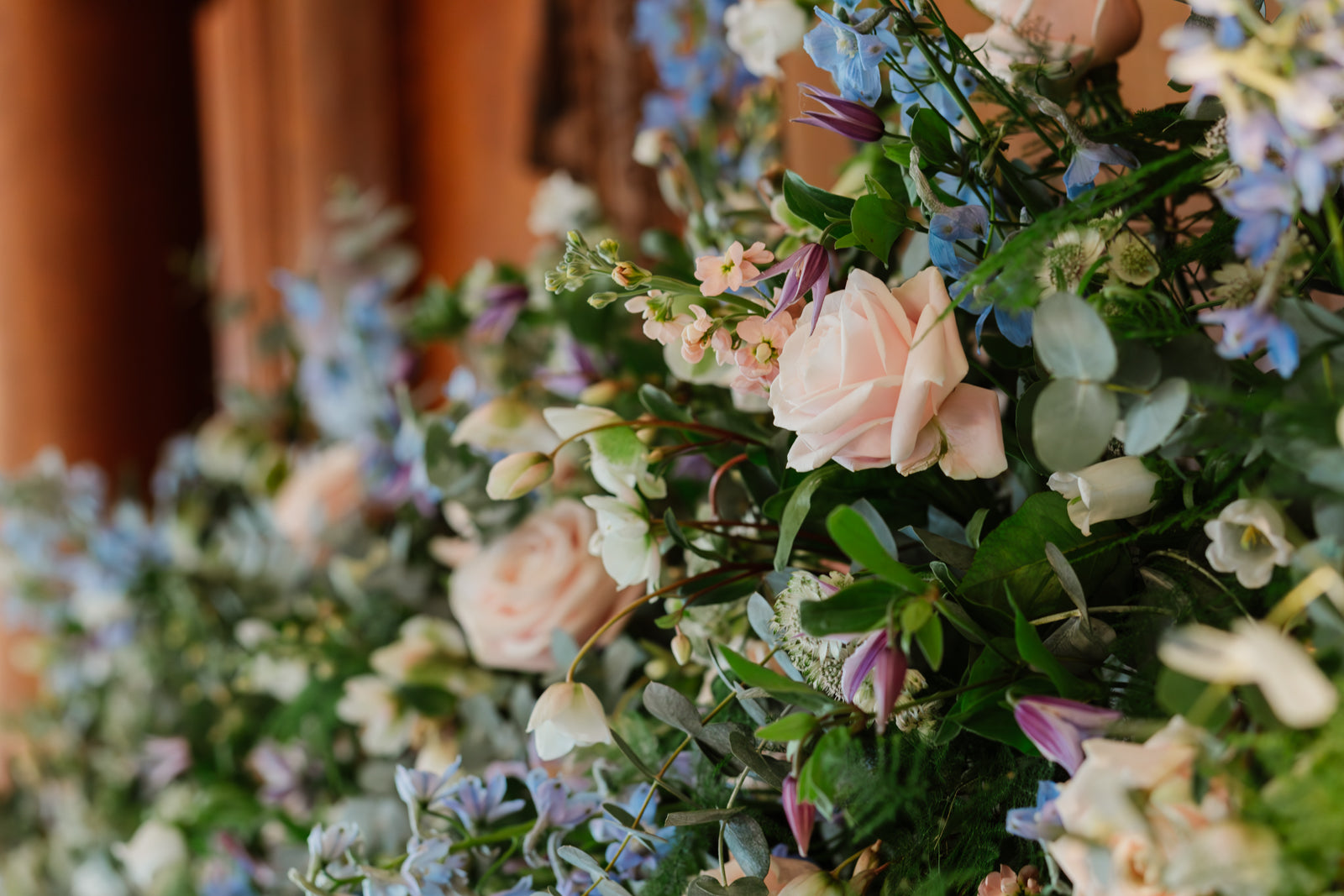 A bespoke sustainable mantel installation with seasonal flowers in pastel colours for a wedding by Gardenia of London