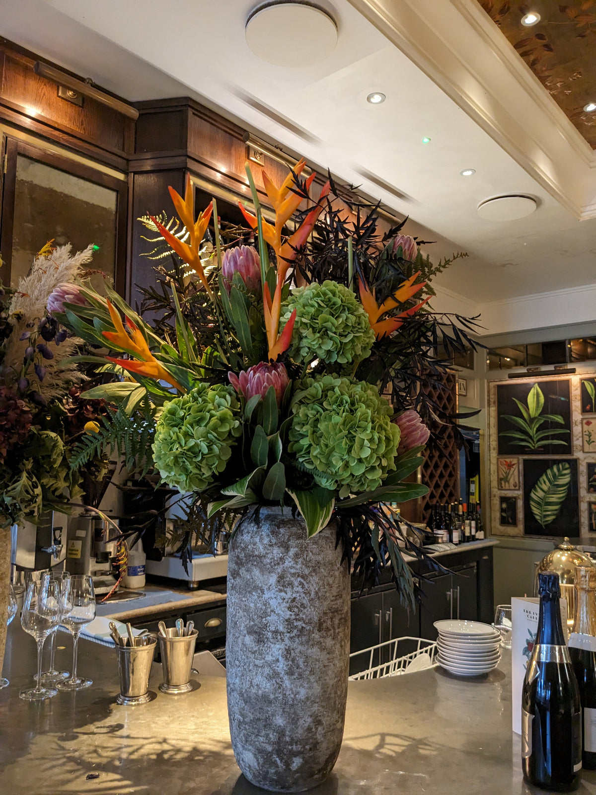 Real large reception vase made by Gardenia with green hydrangeas, birds of paradise and sculptural foliage at a commercial venue